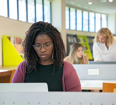 Students and a librarian at computers